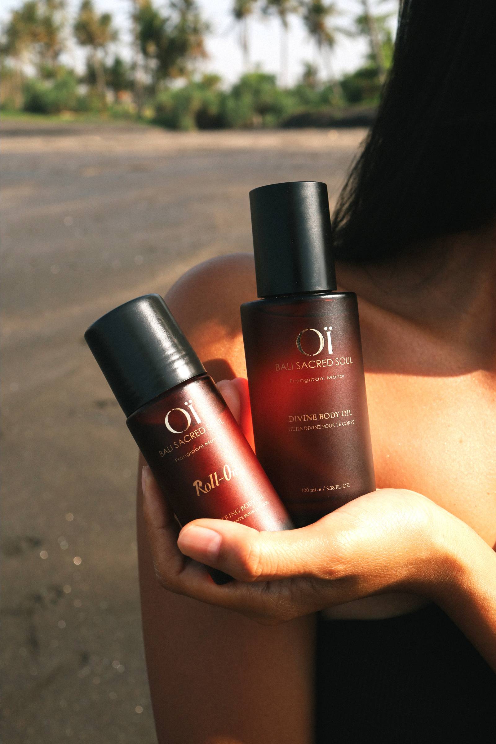 Femme tenant dans a main le duo gratitude ritual : la Divine body oil et le Roll-on
