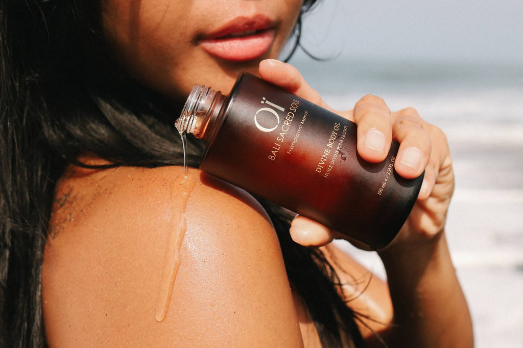 Femme faisant couler sur son épaule la Divine body oil